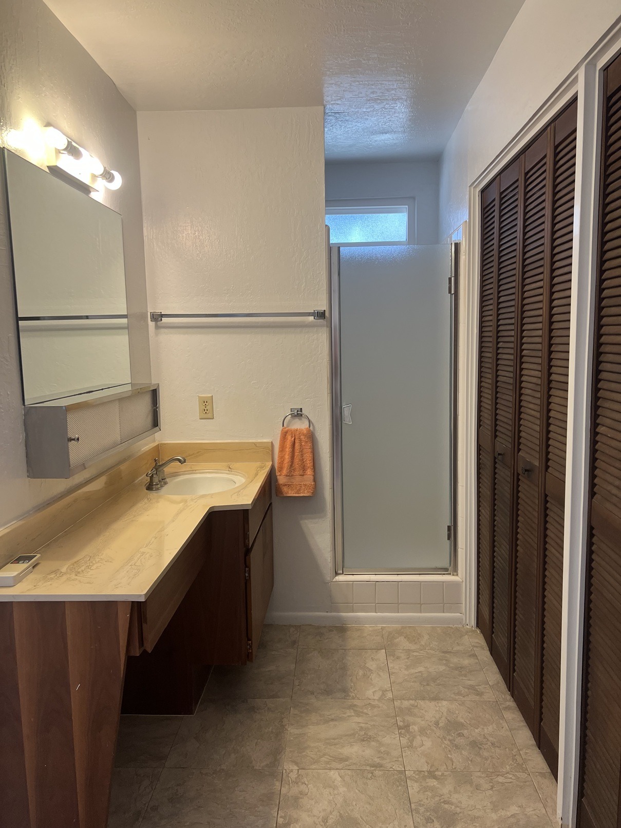 A bathroom with a sink, mirror, and closed door.